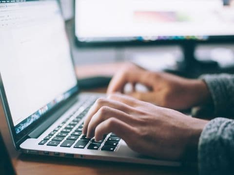 Hands at a keyboard, writing legal content for the public