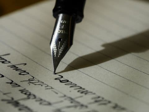 Drafting by hand with a fountain pen on plain paper
